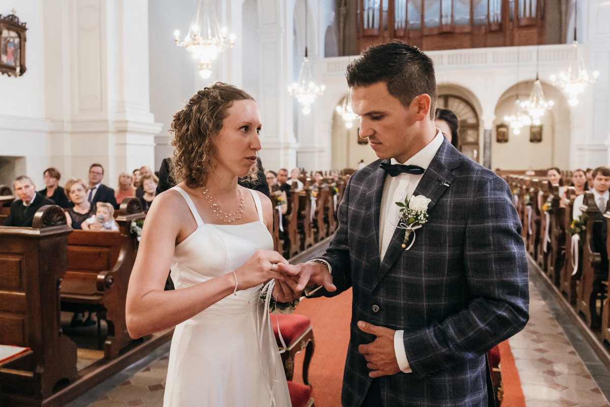 Braut steckt Bräutigam Ring an bei der kirchlichen Trauung in der Stadtkirche Feldbach