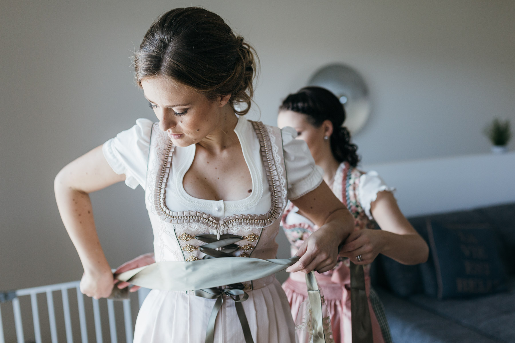 Braut mit Trauzeugin beim Getting-ready, Detail vom Kleid